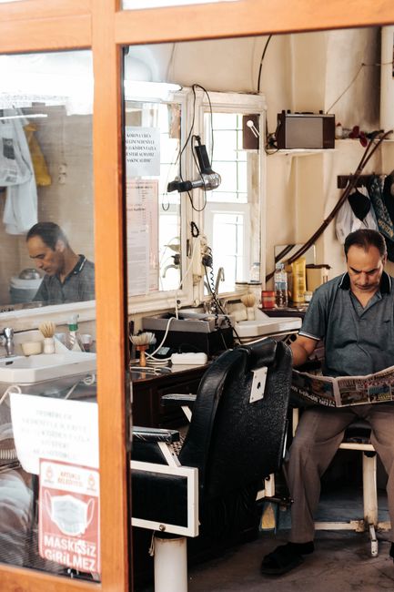 Empty barber chairs in a brick-walled shop