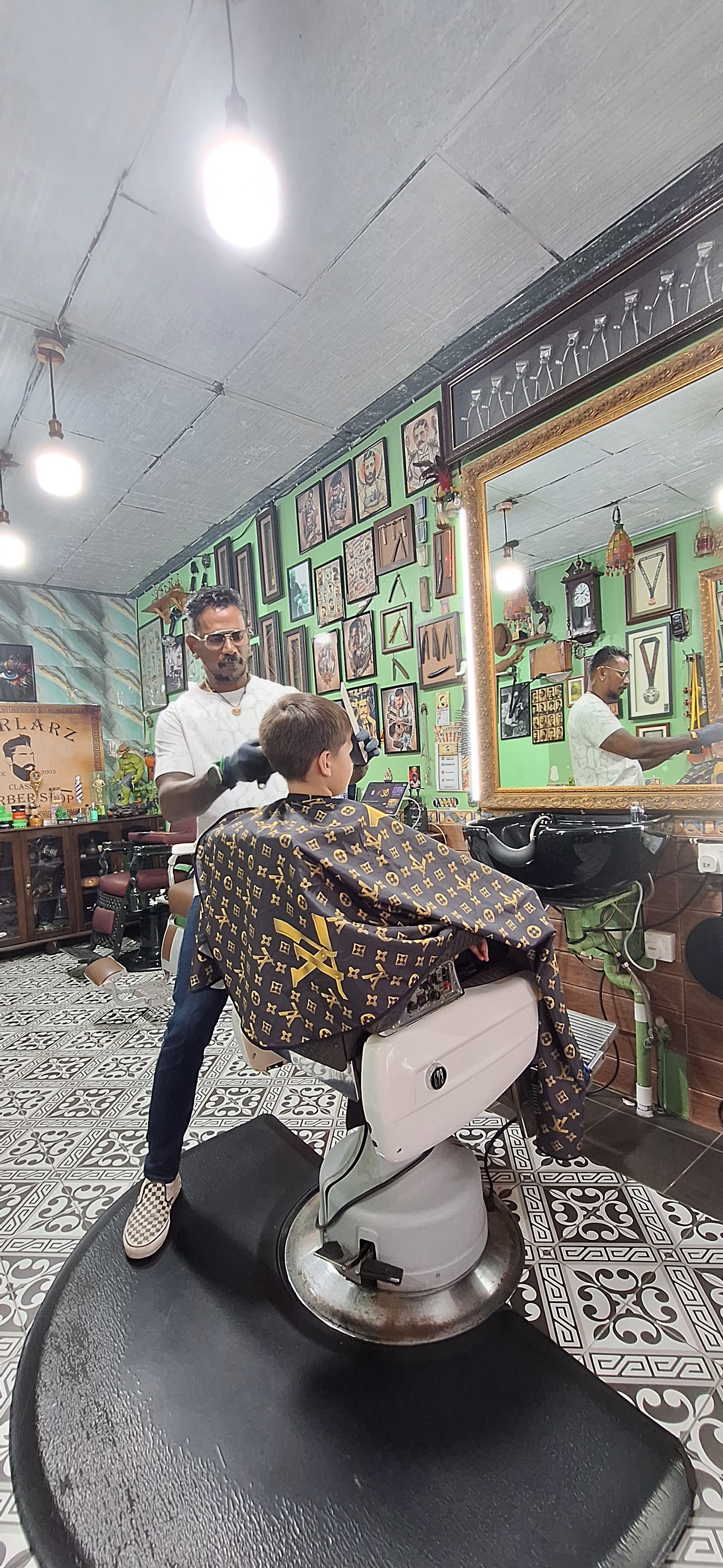 The barber at Verlarz Classic Barber Shop giving a young customer a haircut